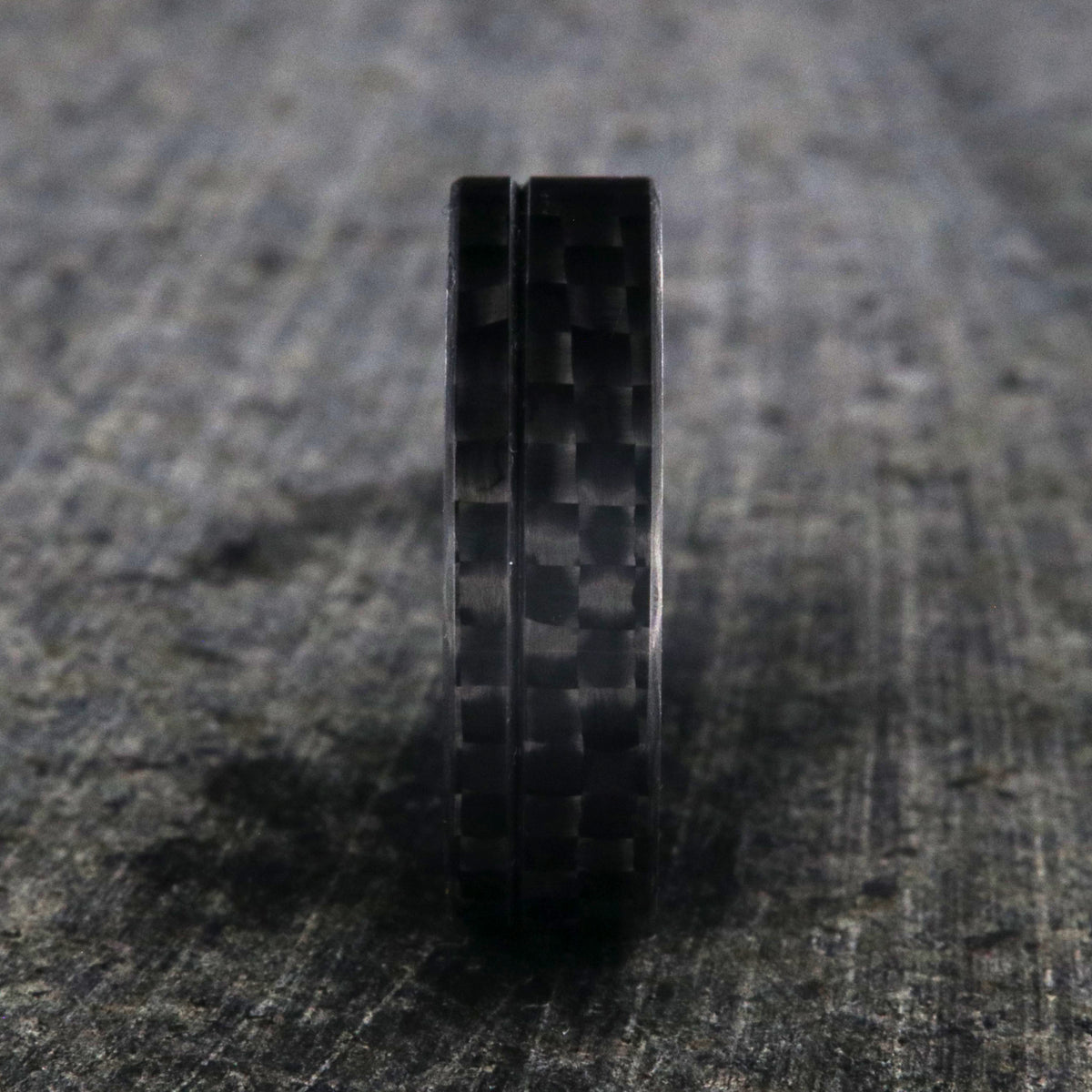 7mm wide black carbon fiber ring with an off-center groove and flat profile