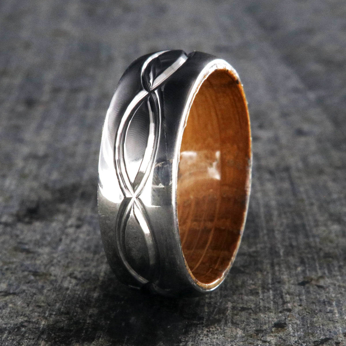8mm wide titanium wedding band with a milled infinity design with a whiskey barrel sleeve