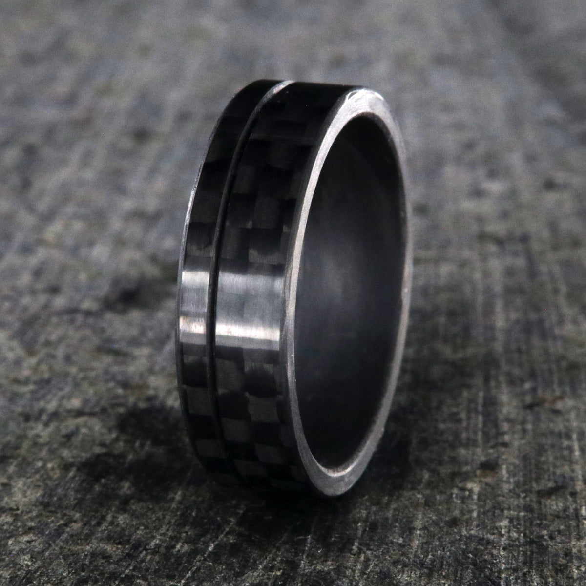 7mm wide black carbon fiber ring with an off-center groove and flat profile