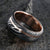 8mm wide men's wedding band made of Damascus steel with a thin off-centered rose gold inlay and solid rose gold sleeve