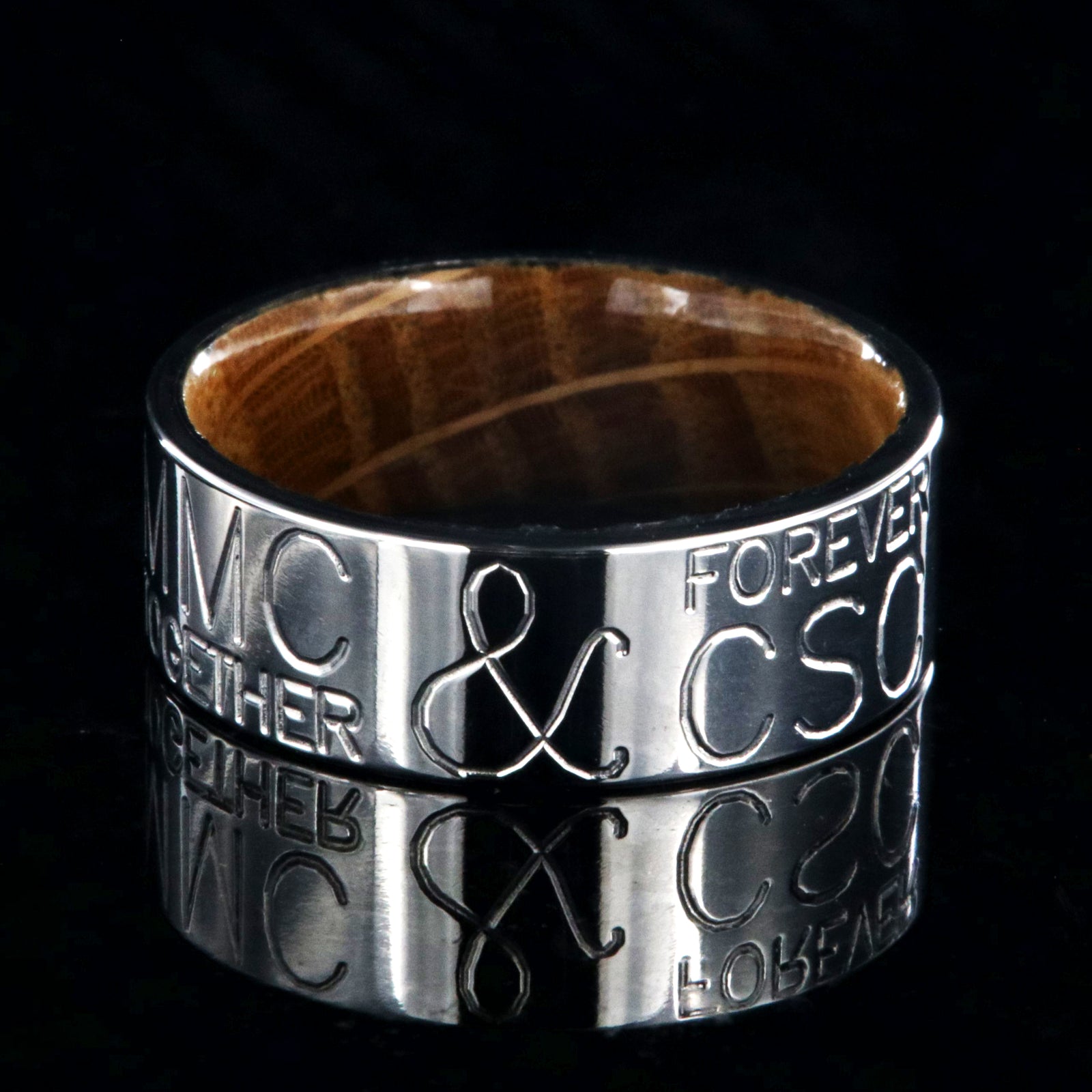 8mm wide personalized duck band ring; polished titanium with two lines of text on either side of an &; polished Jack Daniel's whiskey barrel sleeve