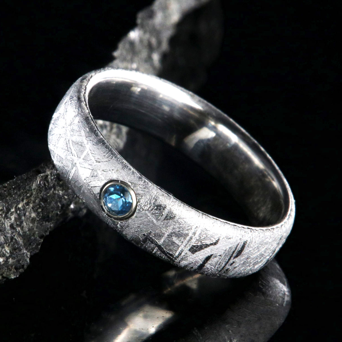 5mm wide women&#39;s meteorite ring with a blue topaz set in 14k gold bezel