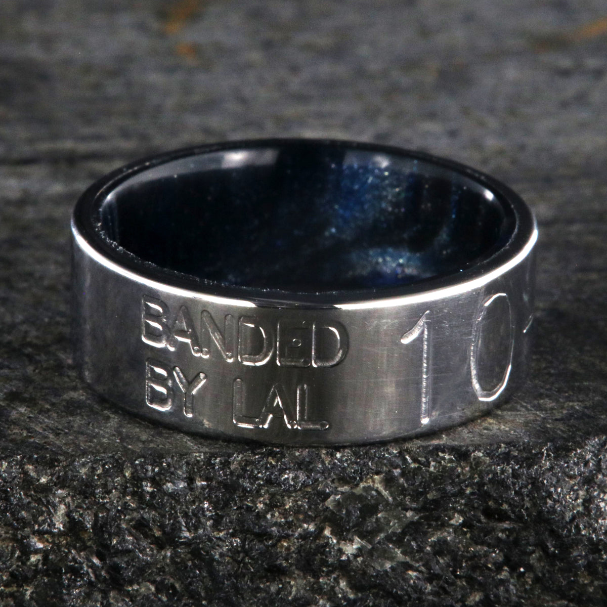 8mm wide duck band titanium ring with two lines of text adjacent to large numbers with dark blue sleeve