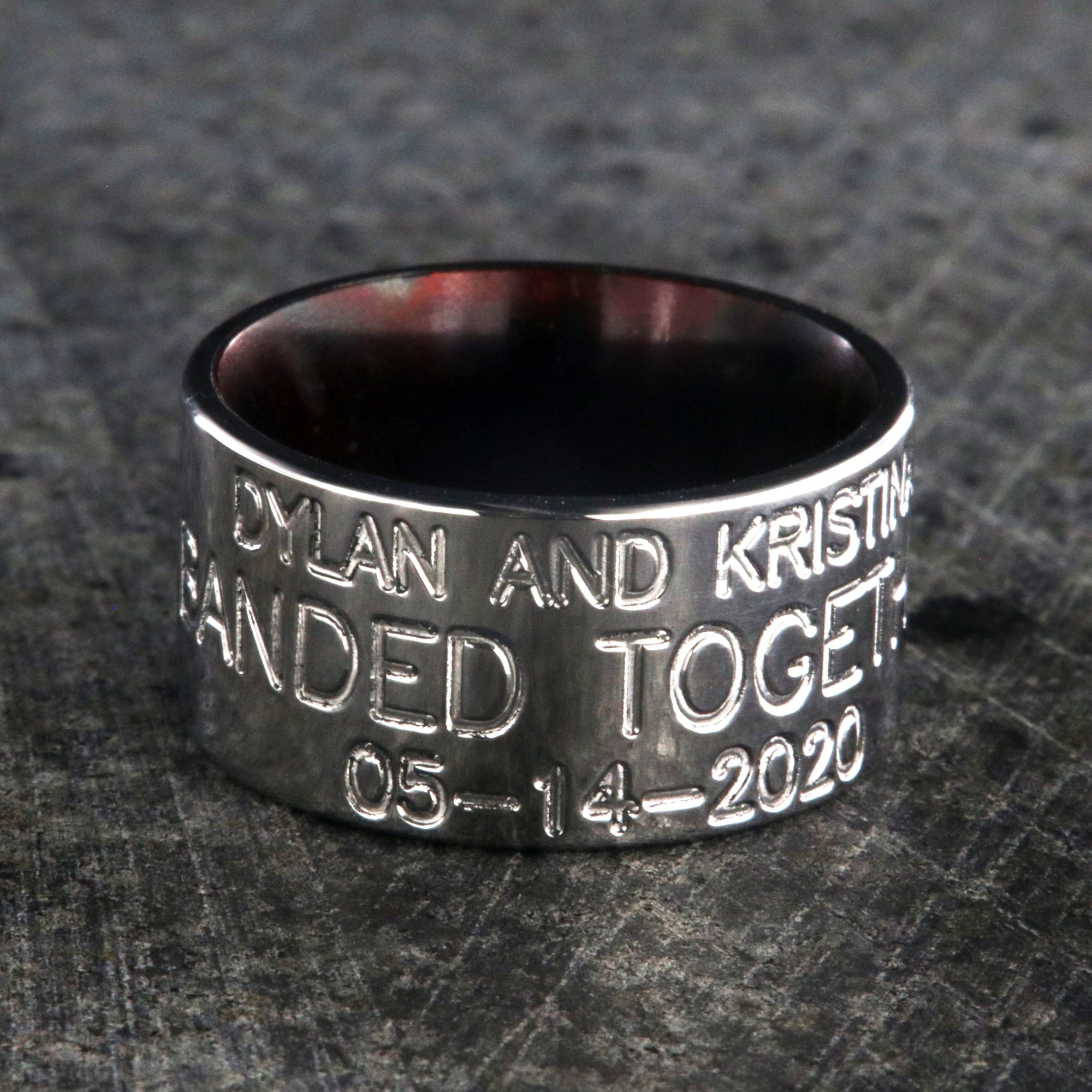 12mm wide titanium duck band ring with 3 lines of text with a dark red sleeve