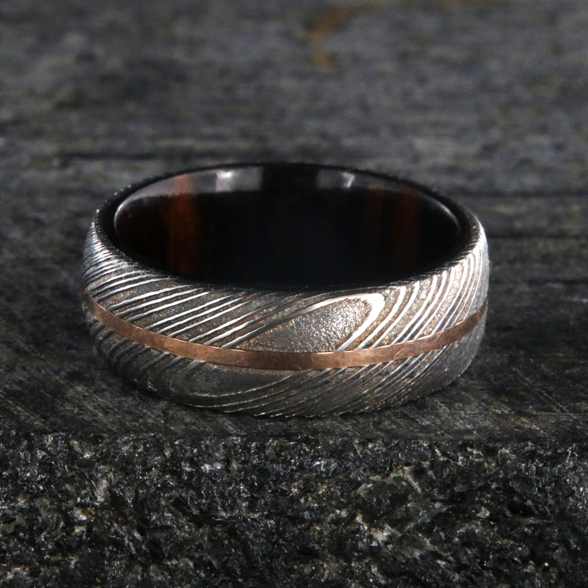 7mm wide men&#39;s Damascus steel wedding ring with a thin centered rose gold inlay and Arizona ironwood sleeve