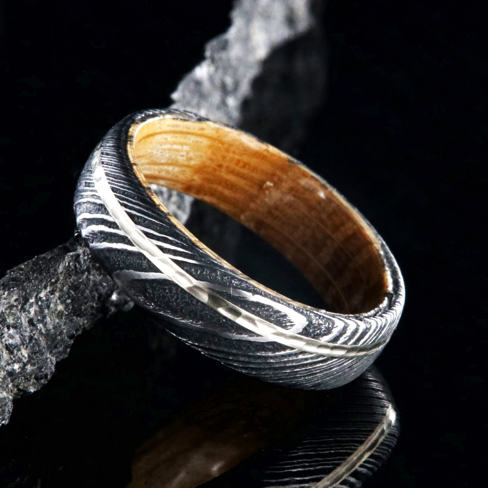 6mm wide black Damascus steel wedding band with a 1mm wide hammered white gold inlay