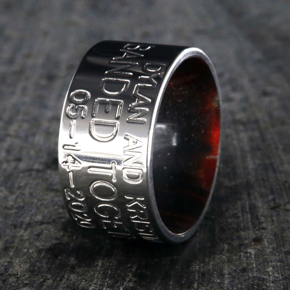 12mm wide titanium duck band ring with 3 lines of text with a dark red sleeve