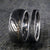 10mm wide men's Damascus steel wedding band with off-center white gold inlay with a 3mm wide women's wedding band of Damascus steel