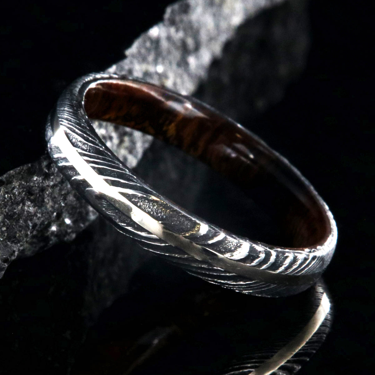 4mm wide black Damascus steel wedding band with a white gold inlay, Arizona ironwood sleeve, and a rounded profile