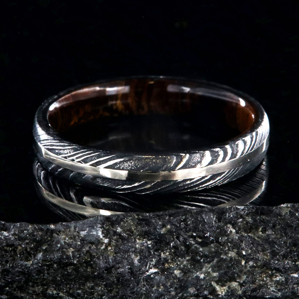 4mm wide black Damascus steel wedding band with a white gold inlay, Arizona ironwood sleeve, and a rounded profile