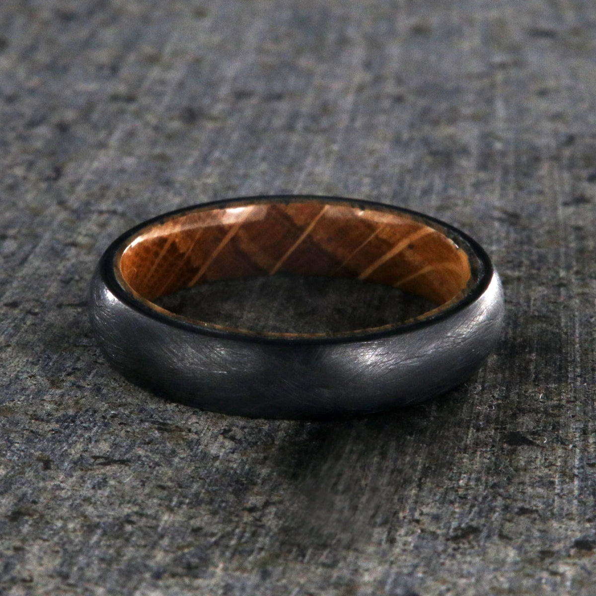 5mm wide black titanium wedding band with a distressed finish, rounded profile, and whiskey barrel sleeve