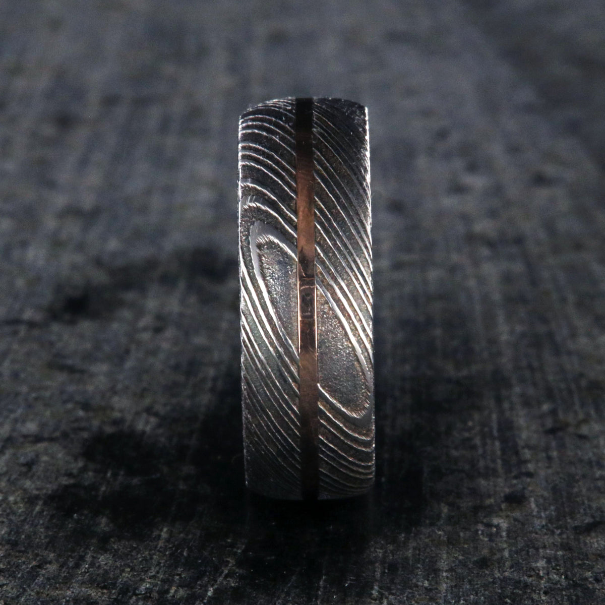 7mm wide men&#39;s Damascus steel wedding ring with a thin centered rose gold inlay and Arizona ironwood sleeve