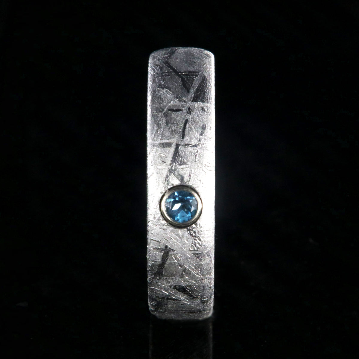 5mm wide women&#39;s meteorite ring with a blue topaz set in 14k gold bezel