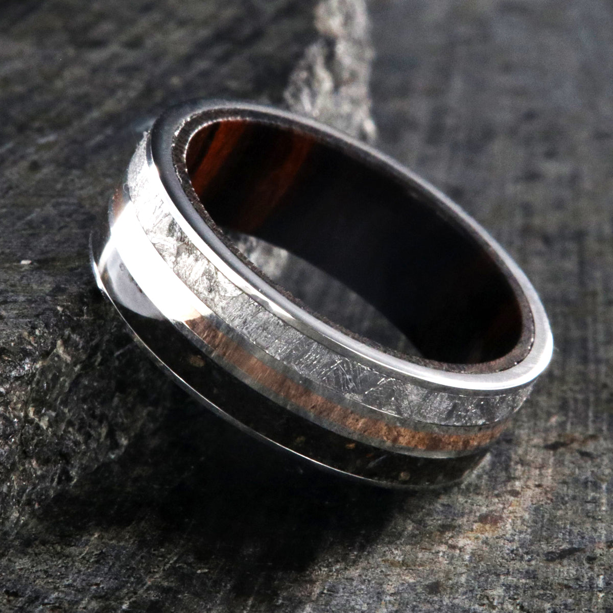 7mm wide wedding band with rose gold center inlay, Gibeon meteorite edge, dinosaur bone edge, and Arizona ironwood sleeve
