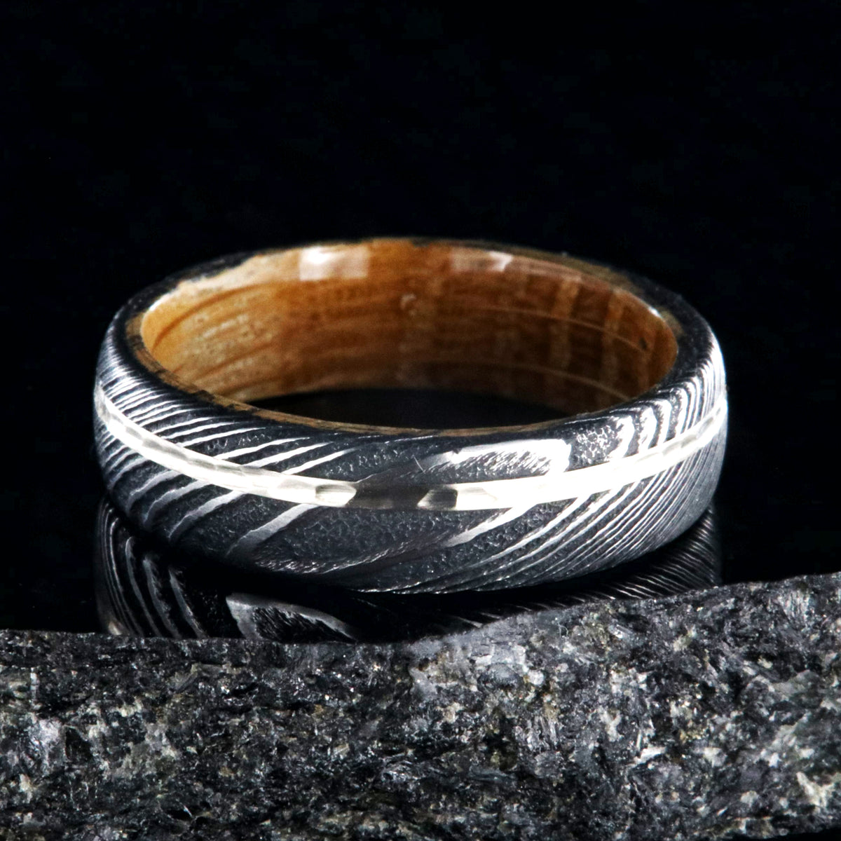 6mm wide black Damascus steel wedding band with a 1mm wide hammered white gold inlay