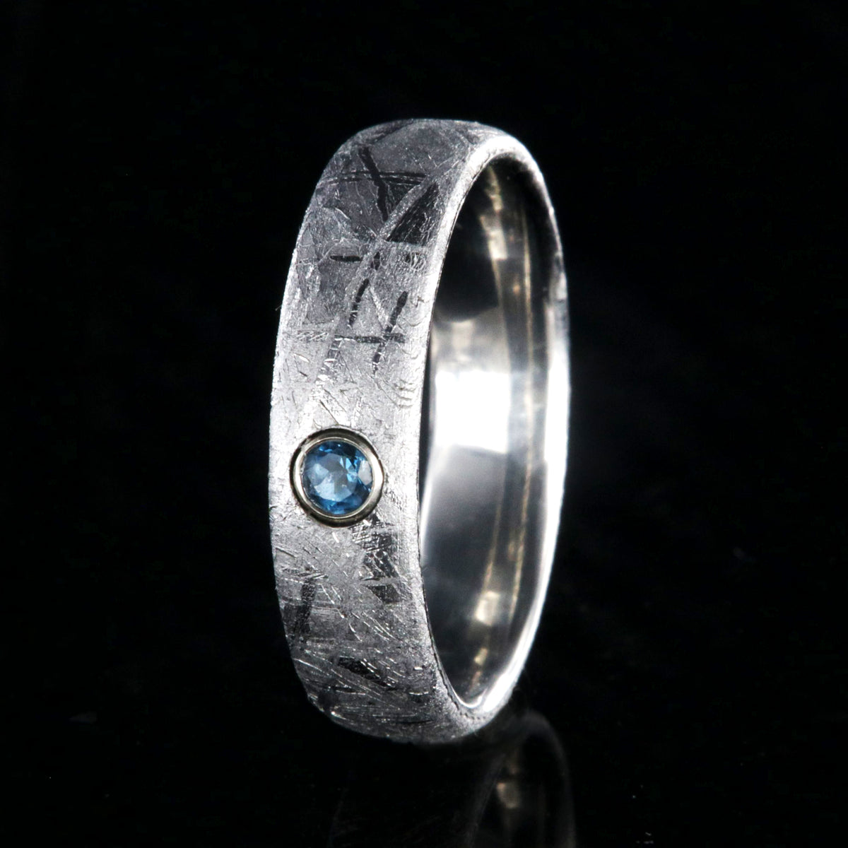 5mm wide women&#39;s meteorite ring with a blue topaz set in 14k gold bezel