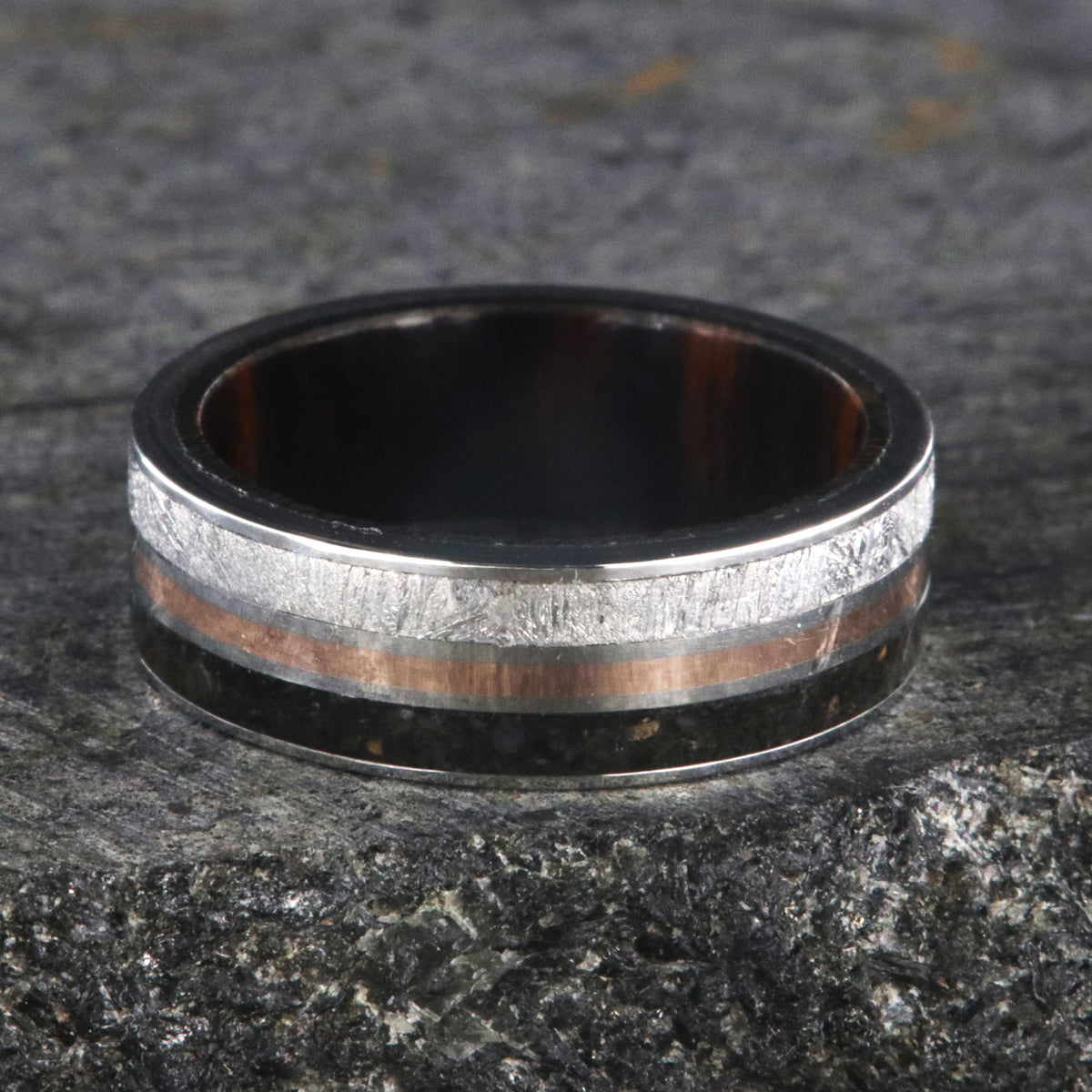 7mm wide wedding band with rose gold center inlay, Gibeon meteorite edge, dinosaur bone edge, and Arizona ironwood sleeve