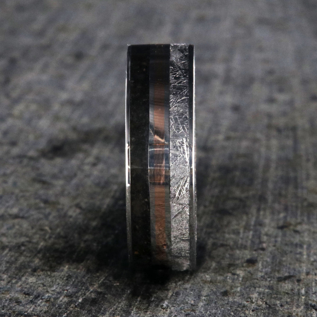 7mm wide wedding band with rose gold center inlay, Gibeon meteorite edge, dinosaur bone edge, and Arizona ironwood sleeve