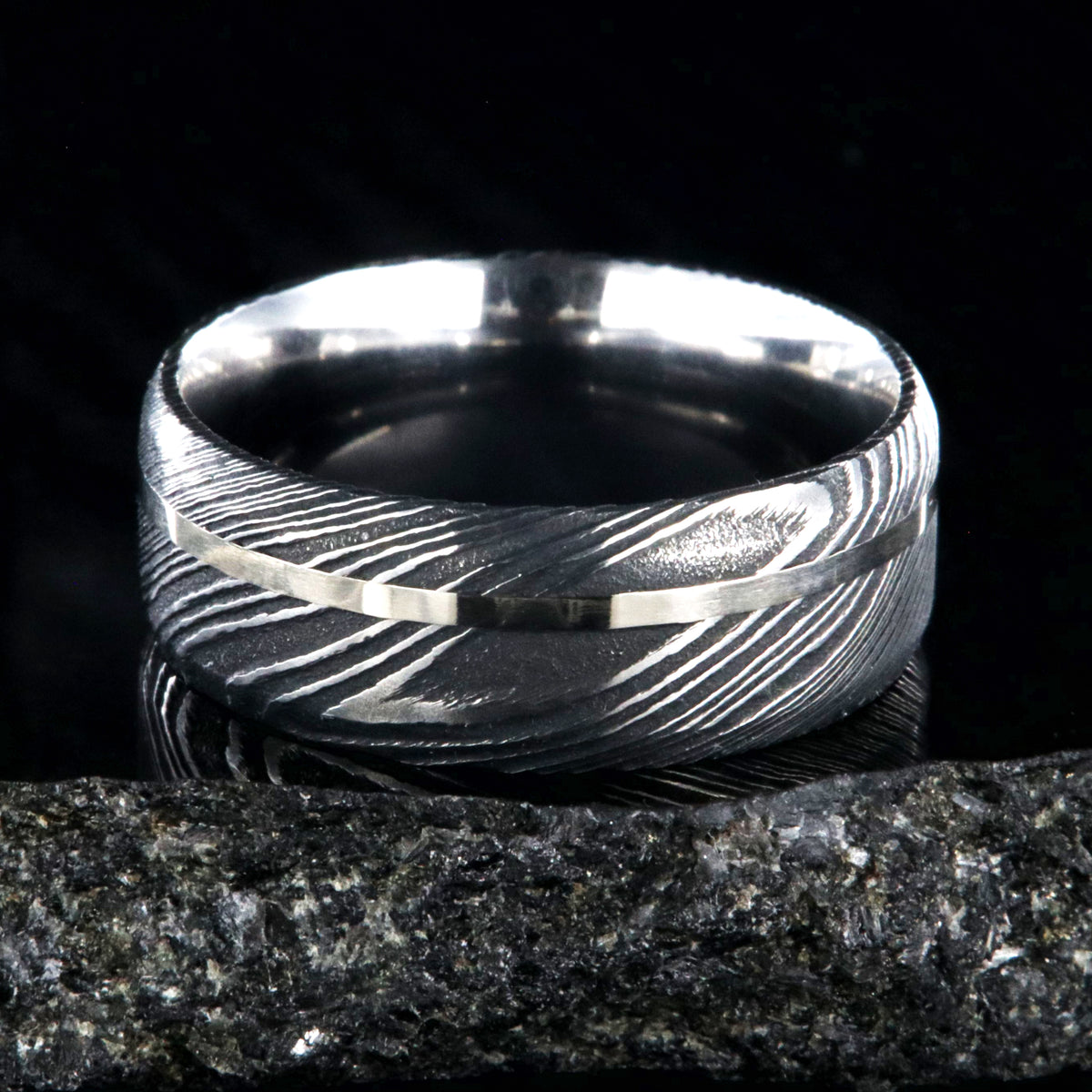 8mm wide black Damascus steel wedding band with a white gold inlay and flat profile