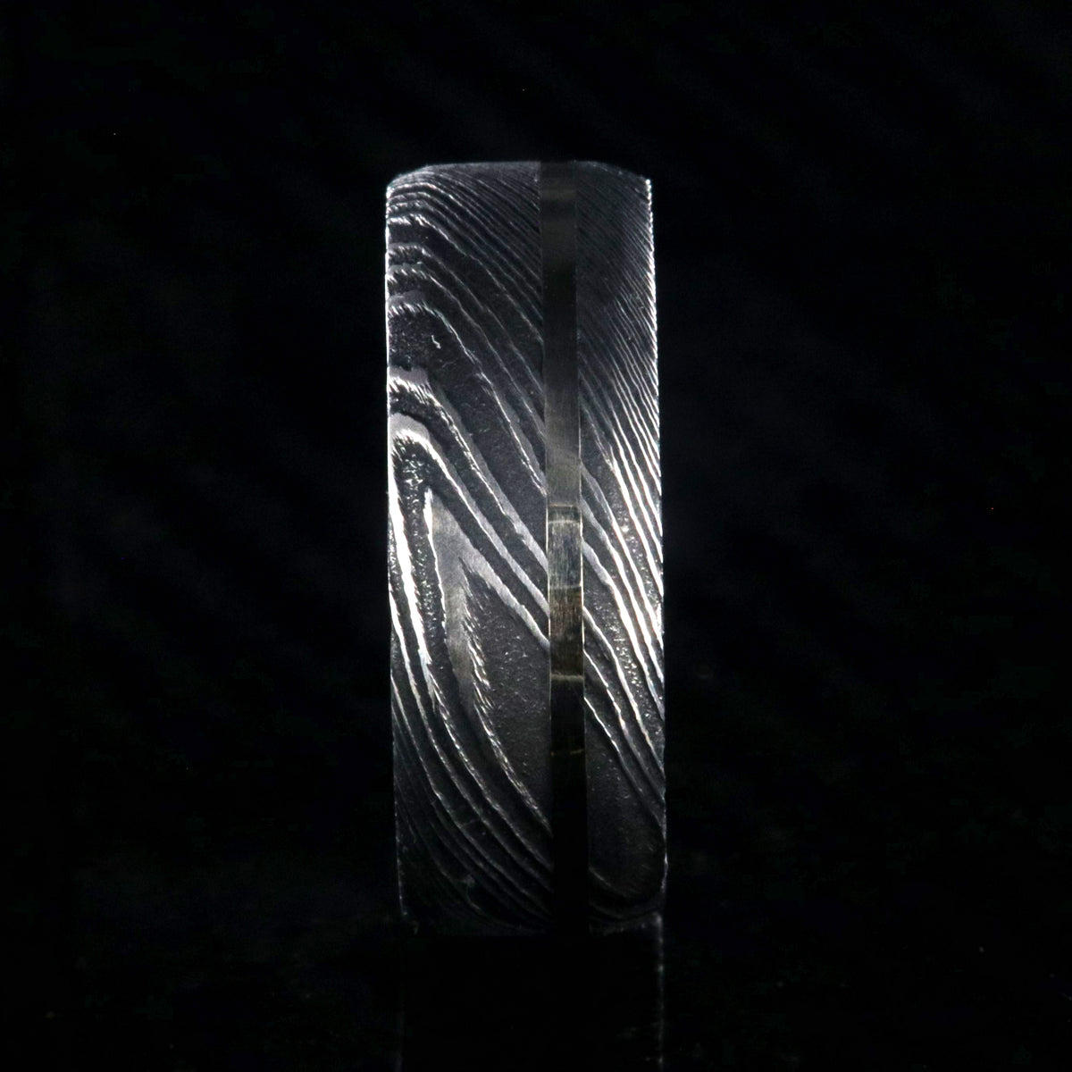 8mm wide black Damascus steel wedding band with a white gold inlay and flat profile