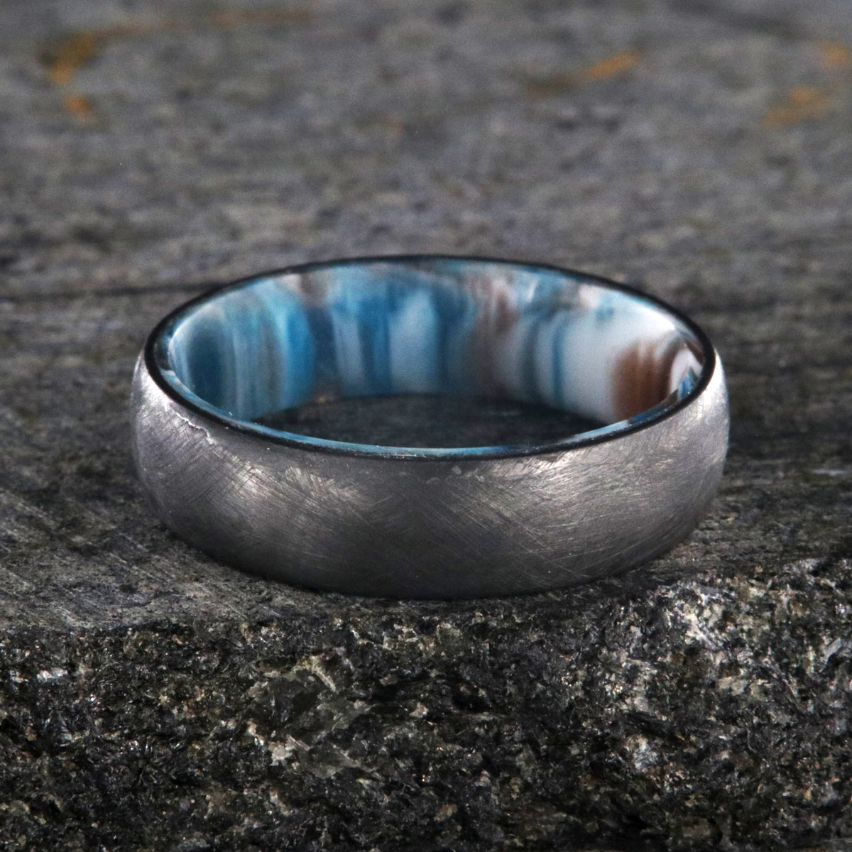6mm wide black zirconium wedding band with a distressed finish and a blue, white, and brown DiamondCast sleeve