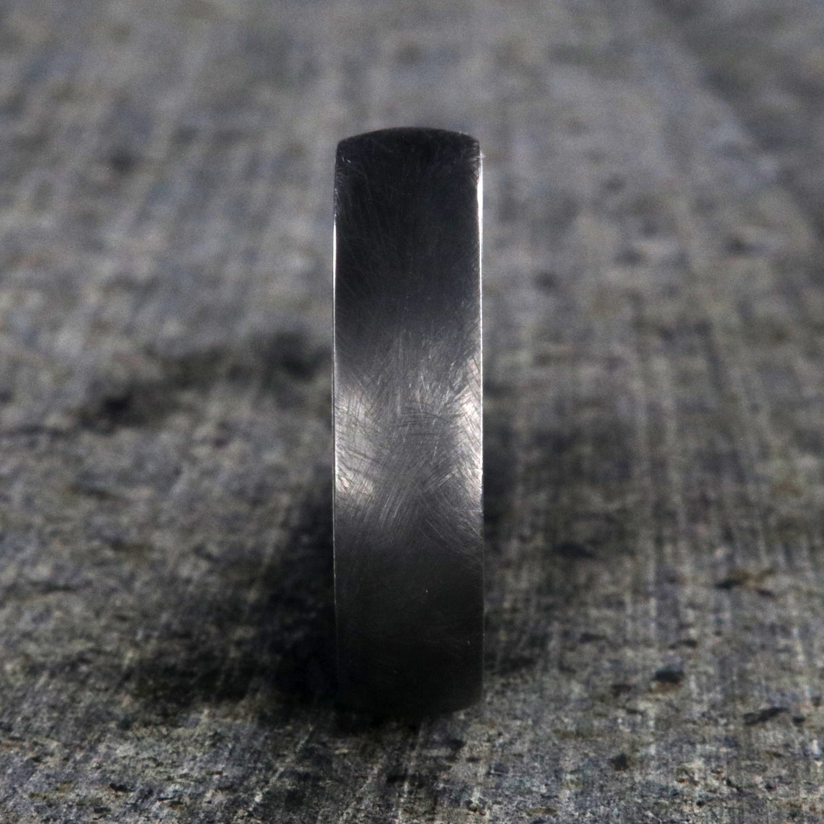 6mm wide black zirconium wedding band with a distressed finish and a blue, white, and brown DiamondCast sleeve