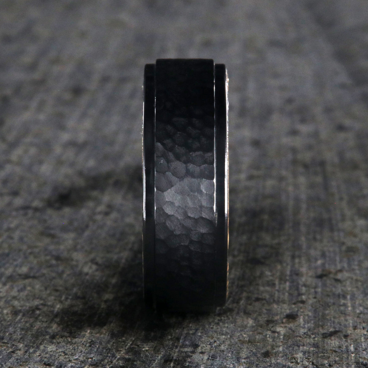8mm wide black titanium wedding band with a raised center and hammered finish with a whiskey barrel sleeve