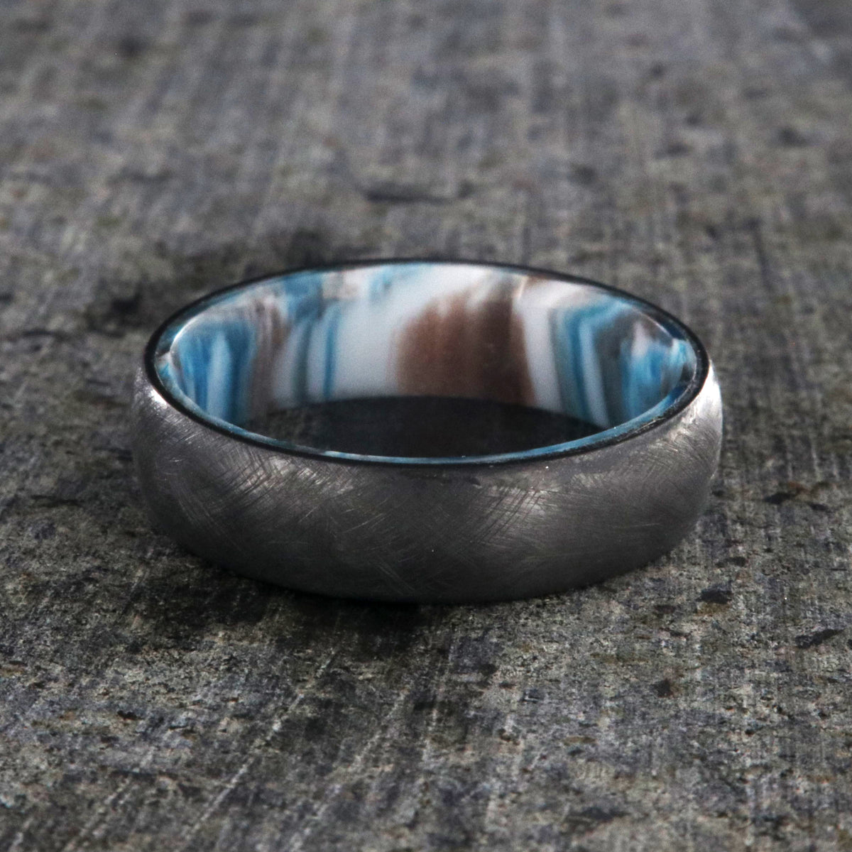 6mm wide black zirconium wedding band with a distressed finish and a blue, white, and brown DiamondCast sleeve