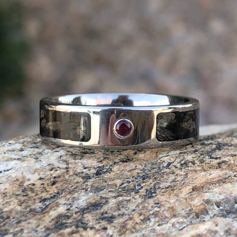 6mm wide titanium ring with a dinosaur inlay and bezel set ruby