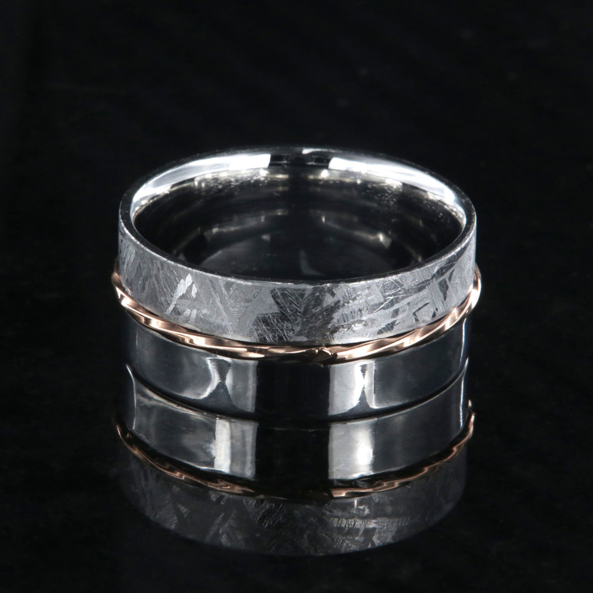 8mm wide men's wedding band with one half meteorite and the other of polish cobalt with a twisted rose gold inlay