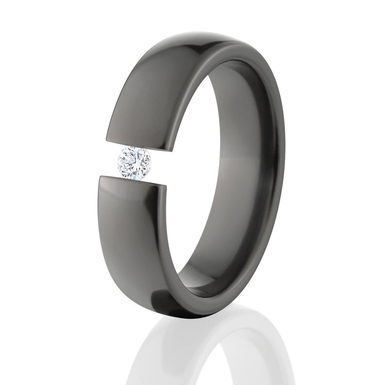 12mm wide black ring with 3 lines of two-toned color text and a 6mm wide black engagement ring with a round CZ stone