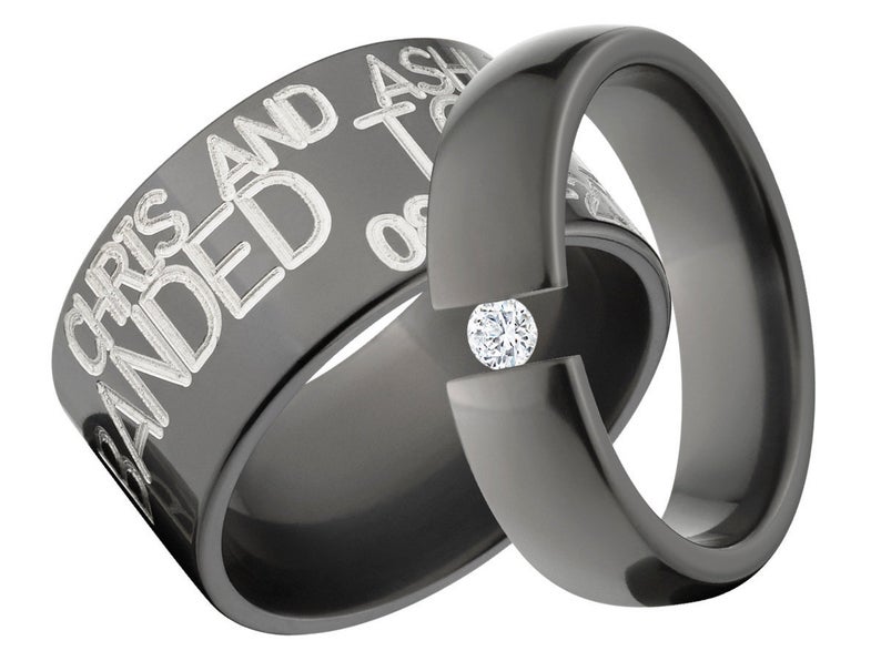 12mm wide black ring with 3 lines of two-toned color text and a 6mm wide black engagement ring with a round CZ stone