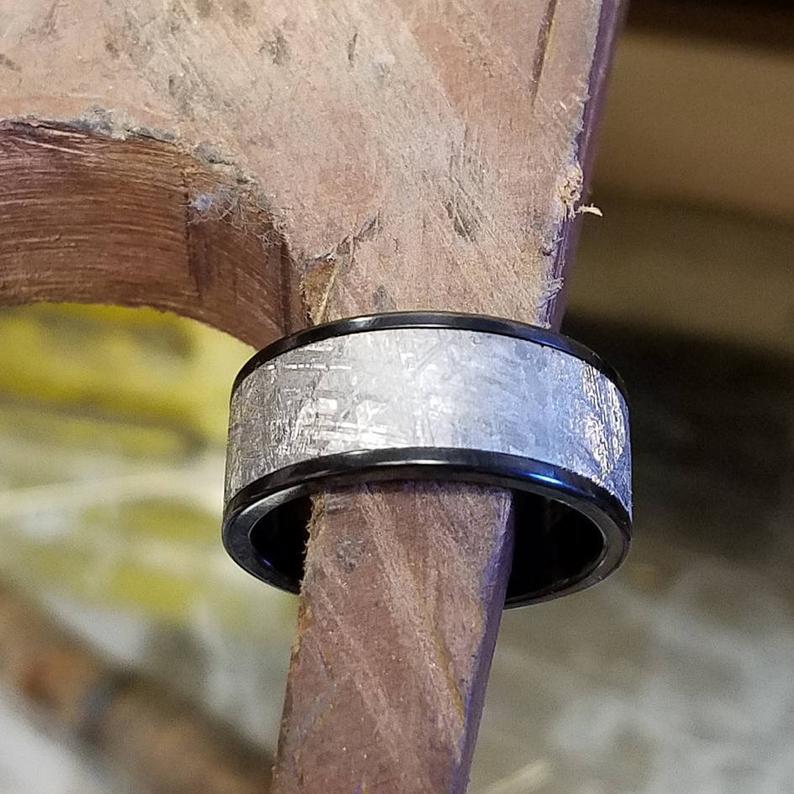 10mm wide meteorite wedding band with black titanium edges and sleeve with a flat profile