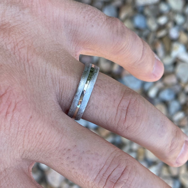 6mm wide cobalt wedding band with Gibeon meteorite on the outside, a white gold center inlay, and cobalt sleeve on man&#39;s hand