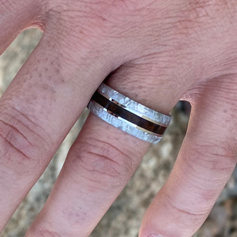 9mm wide Gibeon meteorite ring with beveled edges and Arizona ironwood center inlay on man&#39;s hand