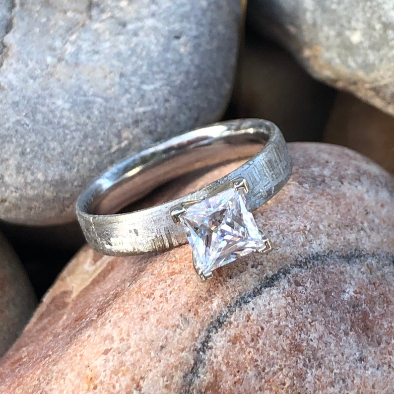 4mm wide women&#39;s meteorite engagement ring with a princess cut moissanite stone