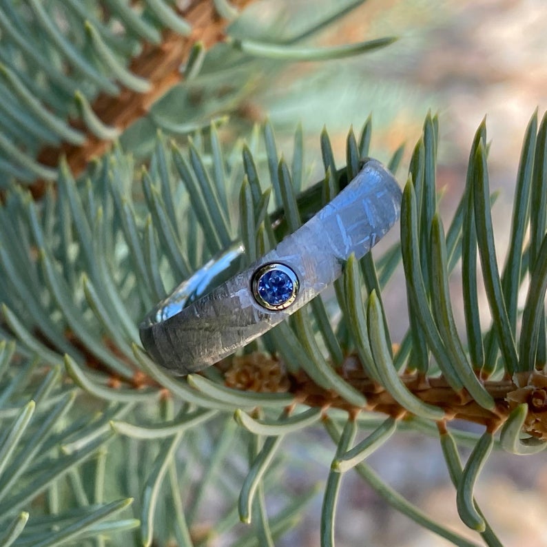 5mm wide women&#39;s meteorite ring with rounded profile and a blue sapphire set in a gold bezel
