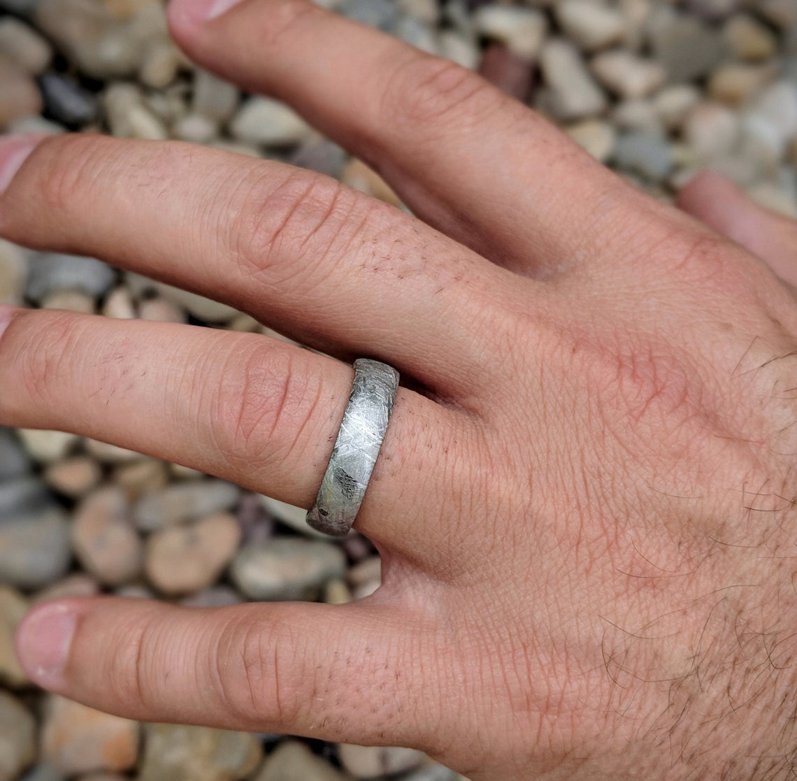 7mm wide meteorite wedding band with cobalt sleeve on man&#39;s hand