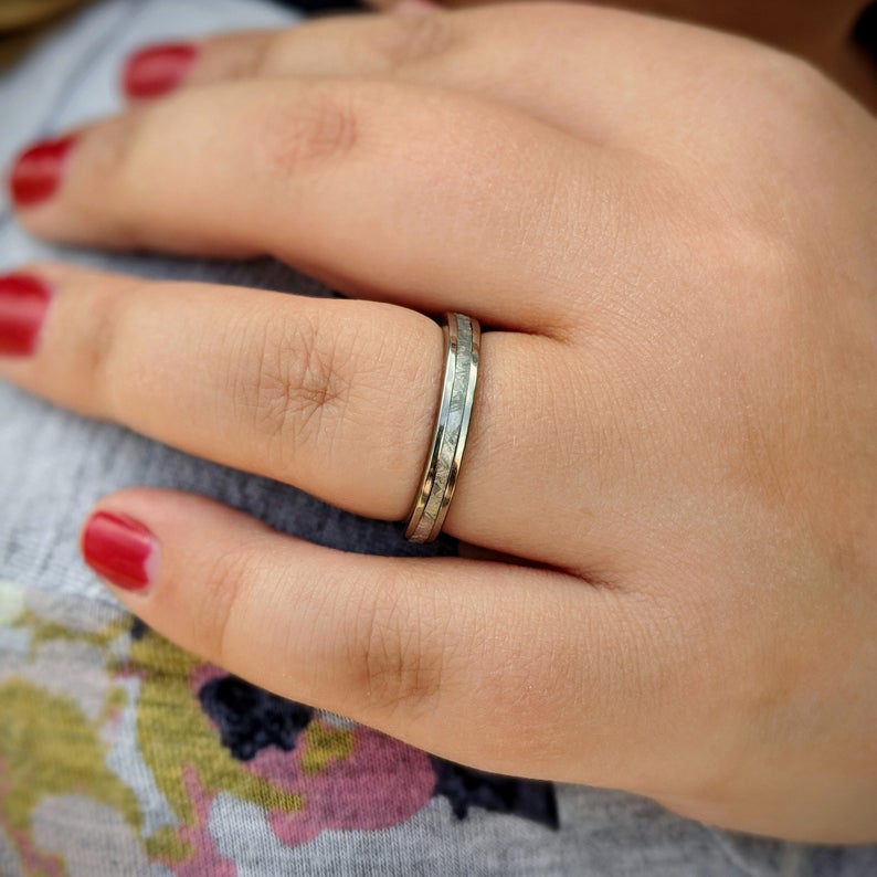 3mm wide women&#39;s meteorite ring with cobalt edges and sleeve on woman&#39;s hand