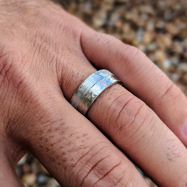 8mm wide meteorite wedding band with half of the ring covered in Gibeon meteorite and the other with a tree bark finish on the cobalt half on man&#39;s hand