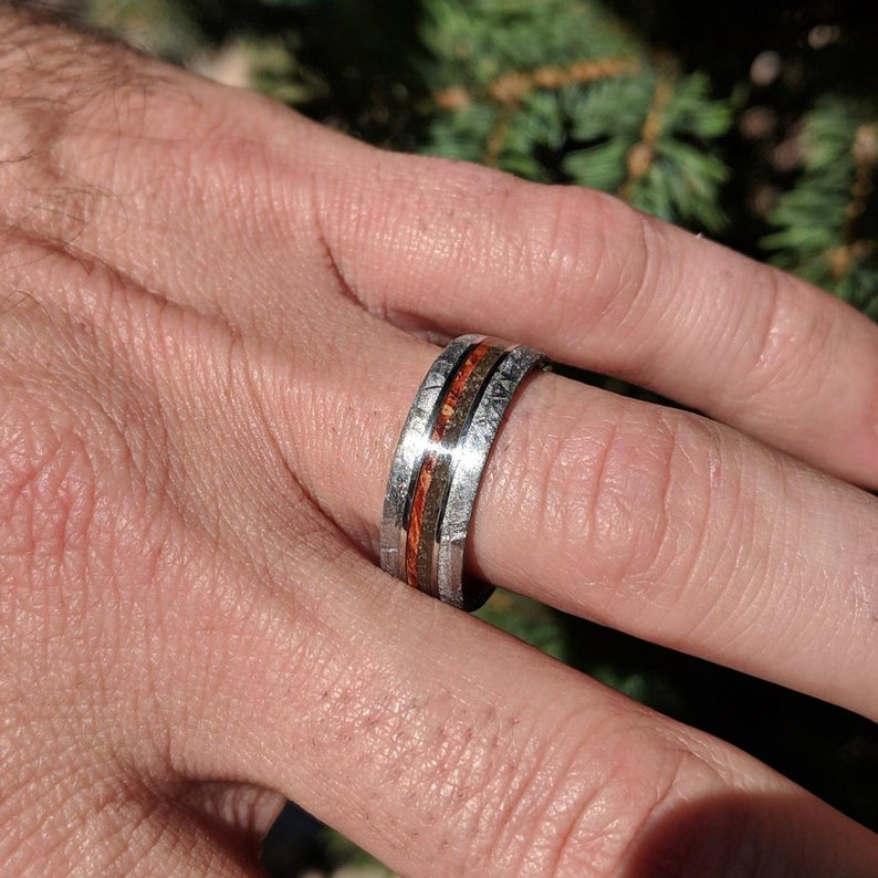 8mm wide flat profile meteorite ring with dinosaur bone and red box elder wood burl on man&#39;s hand