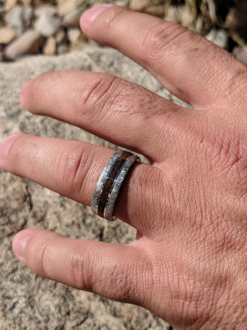 8mm wide memorial ring with two Gibeon meteorite edges and an ashes center on man&#39;s hand