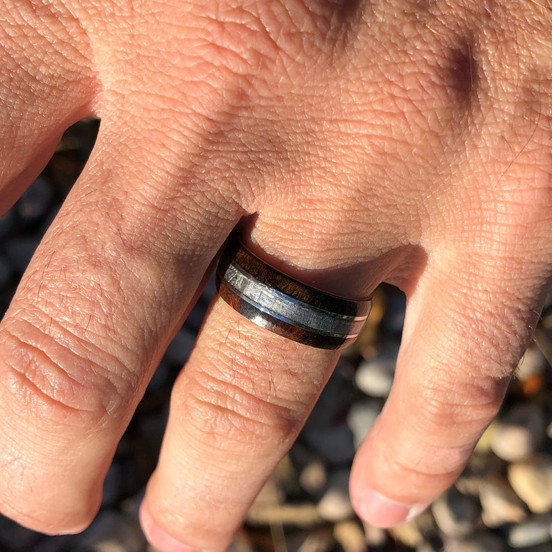 8mm wide men&#39;s cobalt ring with a Gibeon meteorite center inlay and Arizona ironwood edges on man&#39;s hand