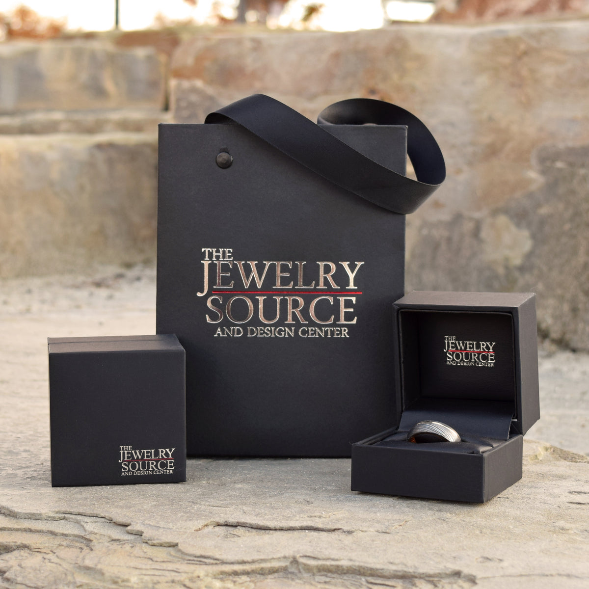black jewelry gift bag with open ring box and mens wedding band