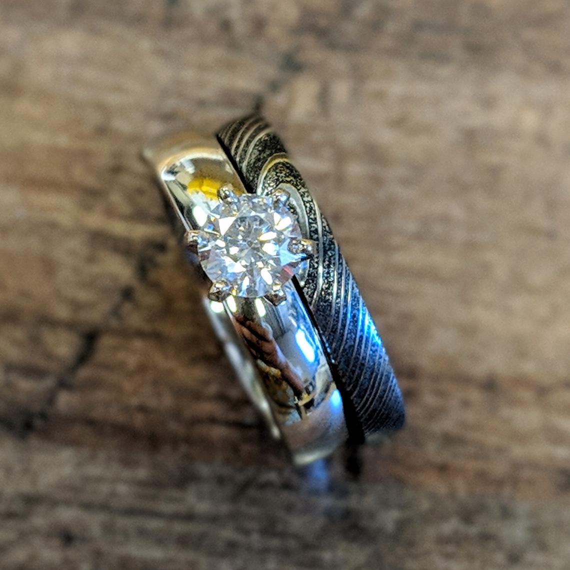 4mm wide cobalt engagement ring with a .5 carat cubic zirconia stone and a 3mm wide black Damascus steel band