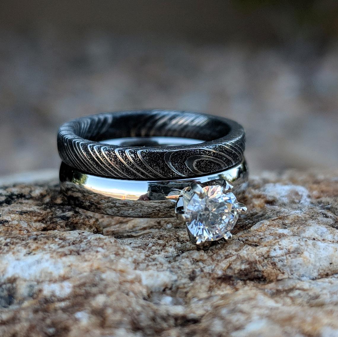 4mm wide cobalt engagement ring with a .5 carat cubic zirconia stone and a 3mm wide black Damascus steel band