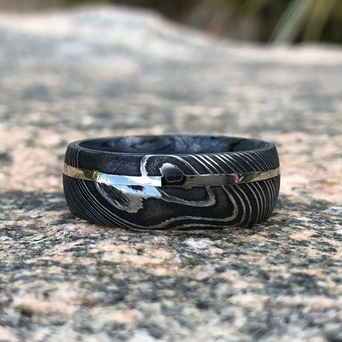 8mm wide Black Damascus steel ring with a white gold inlay and a blue and black cobaltium mokume sleeve