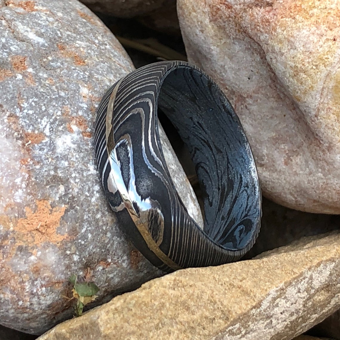 8mm wide Black Damascus steel ring with a white gold inlay and a blue and black cobaltium mokume sleeve