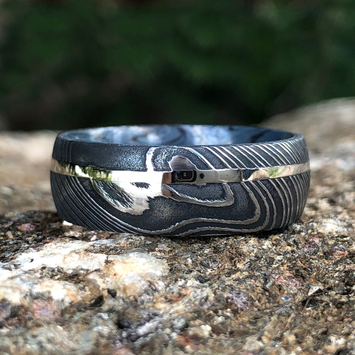 8mm wide Black Damascus steel ring with a white gold inlay and a blue and black cobaltium mokume sleeve