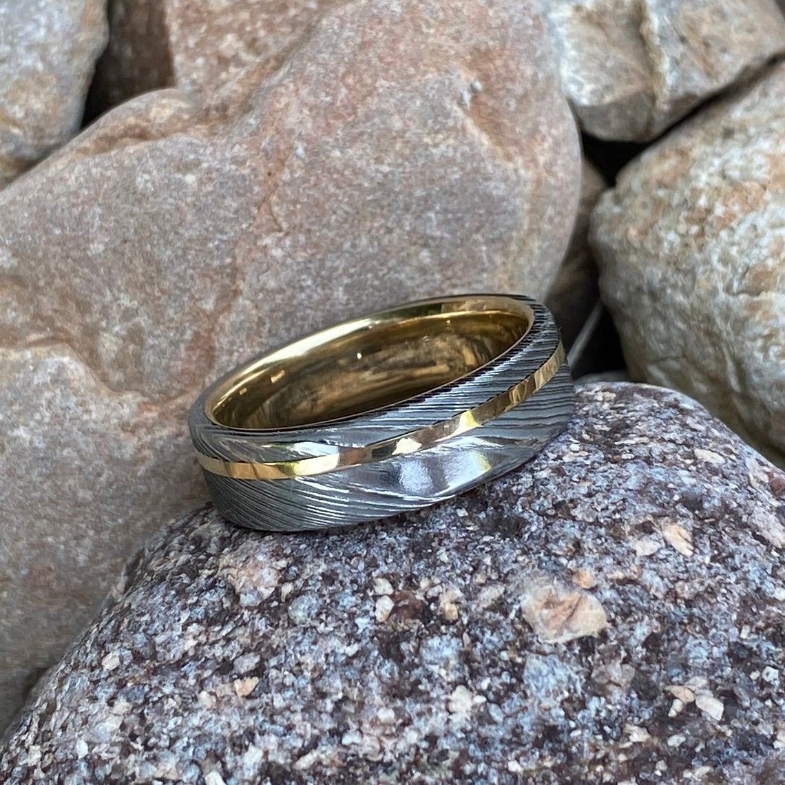 6mm wide white Damascus steel ring with a 14k yellow gold off-center inlay and sleeve